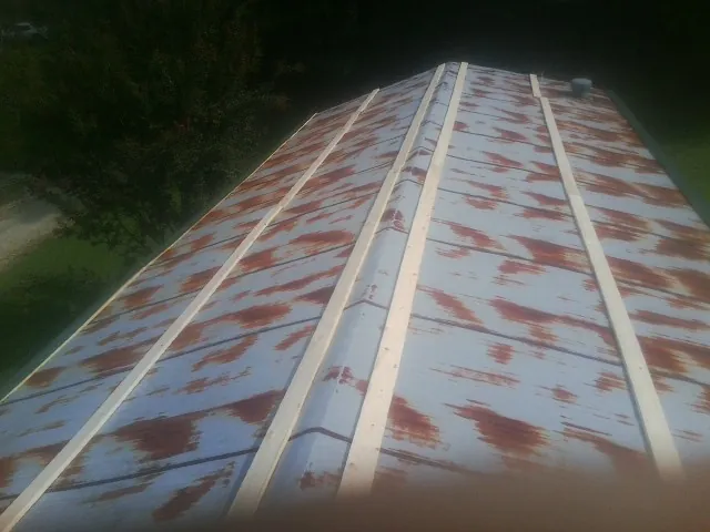 Rusted metal roof panels with new wood purlins before replacement — Storm Damage Roof Repair in Winter Springs by Roofing Brothers