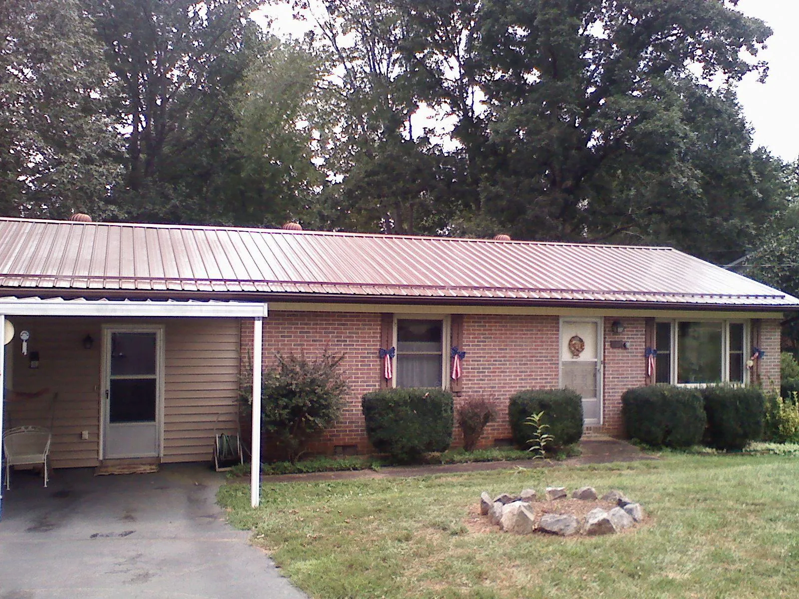 Bronze metal roof and carport on a brick ranch home — Roof Repair work by our crew in Winter Springs
